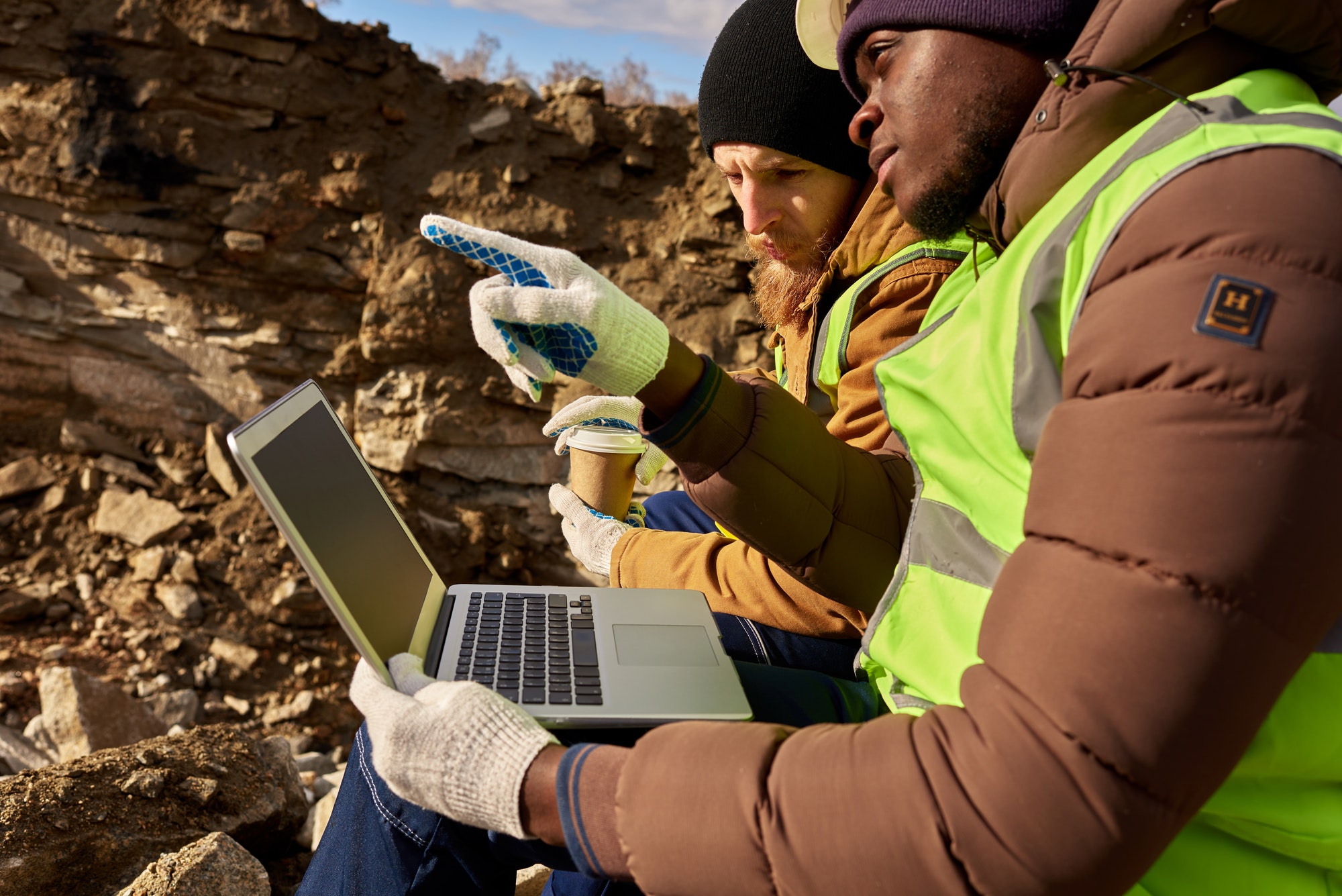 Mining Workers Using Laptop on Excavation Site